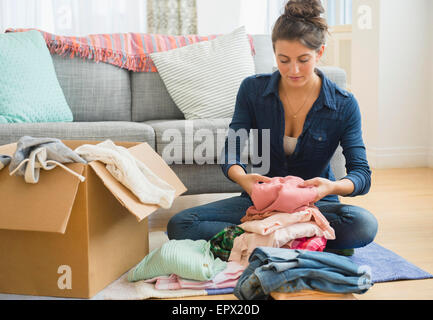 Woman packing clothes to box Stock Photo
