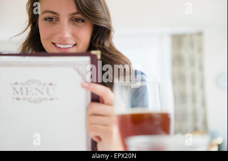 Woman in restaurant reading menu Stock Photo