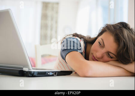 Woman leaning next to laptop Stock Photo