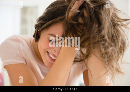 Woman with hands in hair smiling Stock Photo