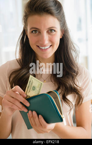 Woman putting banknote to wallet Stock Photo