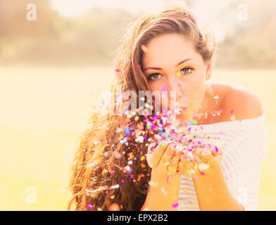 USA, Florida, Jupiter, Young woman blowing confetti Stock Photo