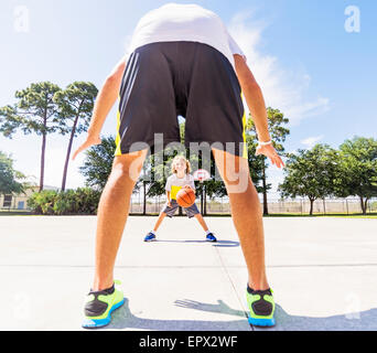 Boy (8-9) playing basketball with his brother Stock Photo