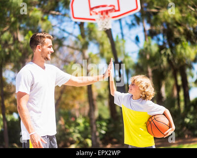 Boy (8-9) high fiving his brother Stock Photo