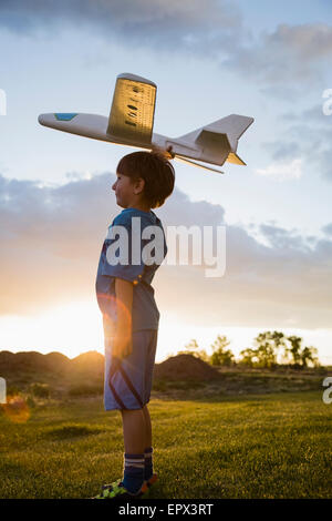 USA, Colorado, Boy (6-7) playing with model airplane outdoors Stock Photo