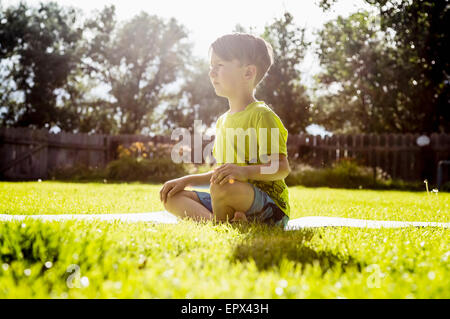 USA, Colorado, Boy (6-7) sitting in grass Stock Photo