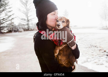 USA, Colorado, Woman holding and kissing dog Stock Photo