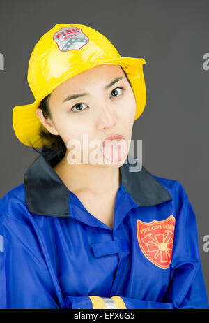 Close up of a tired lady firefighter poking out tongue Stock Photo