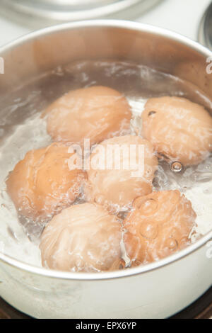Six eggs boiling in a pan of water. Stock Photo