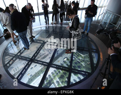 New York, USA. 22nd May, 2015. Members of the media experience the Sky Portal where people are invited to step onto a 14-foot wide circular disc that delivers real-time, high-definition footage of the streets below during a media preview for One World Observatory in New York, the United States, on May 22, 2015. One World Observatory is positioned on top of the tallest building in the Western Hemisphere on levels 100, 101 and 102 of the One World Trade Center building and it will open to the public on May 29. © Qin Lang/Xinhua/Alamy Live News Stock Photo