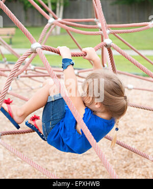 Smiling girl climbing on rope acrobatic gymnastic girl exercising