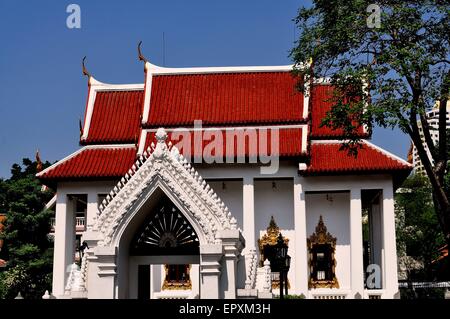 Bangkok, Thailand:  Ornate entrance gate and Ubosot sanctuary hall with orange tile roofs and gilded chofah orrnaments Stock Photo