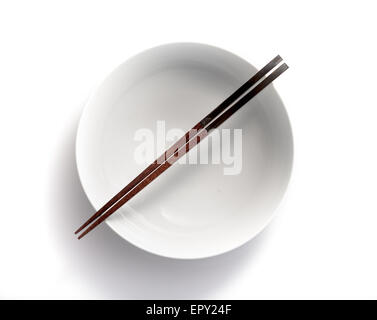 chopsticks in empty bowl isolated on a white background Stock Photo