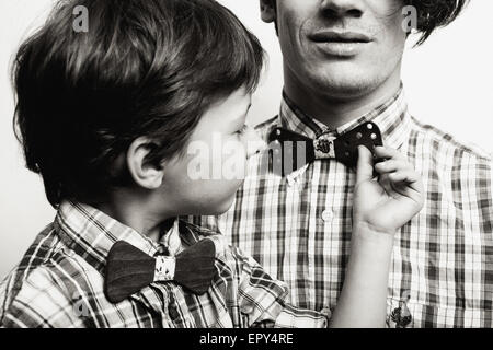 father with son in bowties on white background, casual look fami Stock Photo