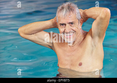 Happy senior man doing aqua fitness in swimming pool in summer Stock Photo