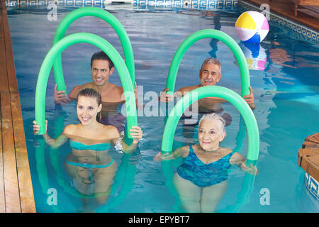 Smiling group doing aqua fitness class together in a swimming pool Stock Photo