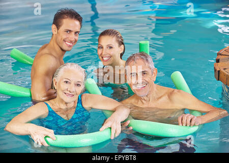 Group with couple and senior citizens having fun in a swimming pool Stock Photo