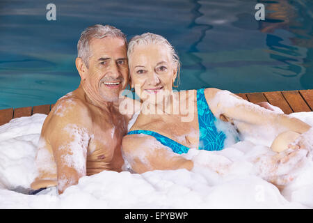 Happy senior couple taking foam bubble bath in a hotel whirlpool Stock Photo