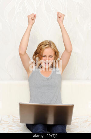 Young woman being happy and putting hands up Stock Photo