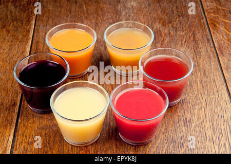 six glasses of variety of organic juices on a wooden vintage table Stock Photo