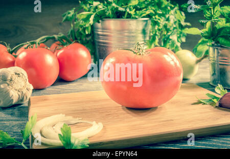 Fresh tomato and vegetables arranged on a wooden table Stock Photo