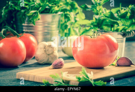 Fresh tomato and vegetables arranged on a wooden table Stock Photo