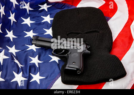 beretta handgun lying on balaclava and united states of america flag Stock Photo