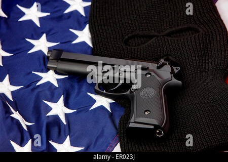 beretta handgun lying on balaclava and united states of america flag Stock Photo
