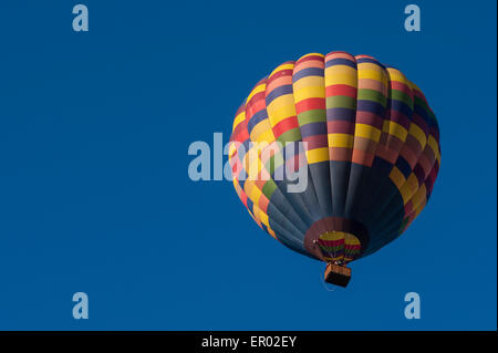 Hot Air balloon lifting off from field at sunrise Stock Photo