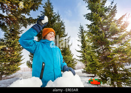 Happy boy ready to throw snowball in forest Stock Photo