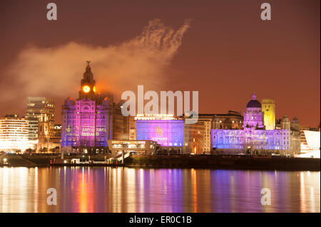 Cunard Shipping Line is celebrating its 175th anniversary with an event called One Magnificent City. The Three Queens of Cunard - it's three ships - Queen Mary 2, Queen Victoria and Queen Elizabeth sail into Liverpool together. Photo shows the Cunard ship Queen Mary 2 Ship against the world famous Cunard Building, centre, on Liverpool Waterfront illuminated by fireworks in celebration. To the left of centre is the Royal Liver Building and to right of centre is the Port of Liverpool Building Stock Photo