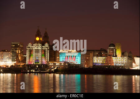 Cunard Shipping Line is celebrating its 175th anniversary with an event called One Magnificent City. The Three Queens of Cunard - it's three ships - Queen Mary 2, Queen Victoria and Queen Elizabeth sail into Liverpool together. Photo shows the Cunard ship Queen Mary 2 Ship against the world famous Cunard Building, centre, on Liverpool Waterfront illuminated by fireworks in celebration. To the left of centre is the Royal Liver Building and to right of centre is the Port of Liverpool Building Stock Photo