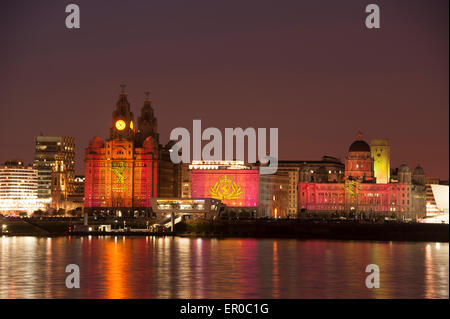 Cunard Shipping Line is celebrating its 175th anniversary with an event called One Magnificent City. The Three Queens of Cunard - it's three ships - Queen Mary 2, Queen Victoria and Queen Elizabeth sail into Liverpool together. Photo shows the Cunard ship Queen Mary 2 Ship against the world famous Cunard Building, centre, on Liverpool Waterfront illuminated by fireworks in celebration. To the left of centre is the Royal Liver Building and to right of centre is the Port of Liverpool Building Stock Photo