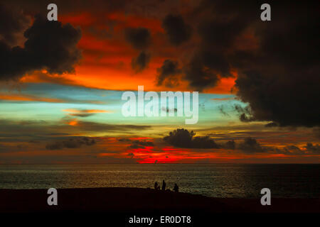 Silhouettes of people on the beach, watching the colorful sunset Stock Photo