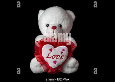 White teddy bear isolated on black background. Stock Photo