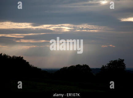 Sun's rays break through a cloud layer on a cold February afternoon Stock Photo