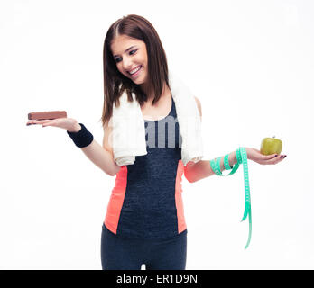 Smiling woman making choice between bananas and chocolate isolated on a white background Stock Photo