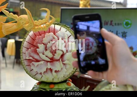 Beijing, China. 25th May, 2015. A visitor takes picture of watermelon carving during the 27th Daxing Watermelon Festival in Panggezhuang Township of Daxing District of Beijing, capital of China, May 25, 2015. Credit:  Gao Jianjun/Xinhua/Alamy Live News Stock Photo