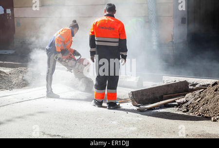 Saint-Petersburg, Russia - May 32, 2015: men at work, urban road under construction, sawing of a roadside border stones Stock Photo