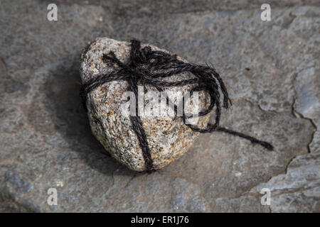Tome Ishi is a stone is wrapped in rope and placed in a path or in front of a gate. They're sometimes called 'stop stones' Stock Photo