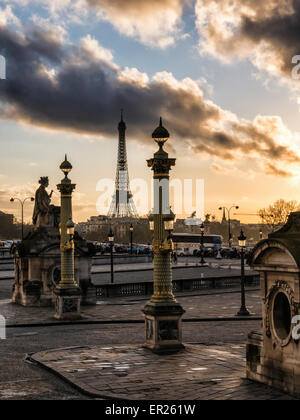 Paris, Place de la Concorde, Eiffel Tower, Statue, lampposts and dramatic golden light and cloudy sky at sunset Stock Photo