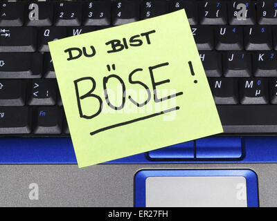 Memo note on notebook, Du bist böse you are mean Stock Photo