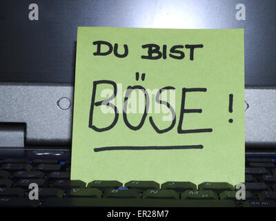 Memo note on notebook, Du bist böse you are mean Stock Photo