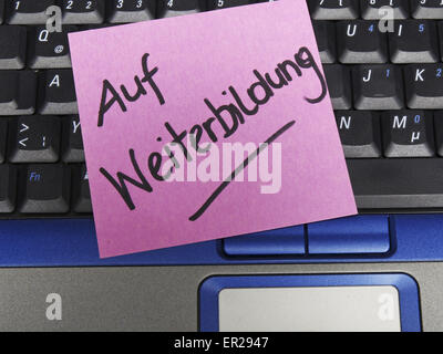 Memo note on notebook, on further education Stock Photo
