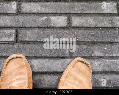 Male, brown suede shoes on concrete tiles Stock Photo