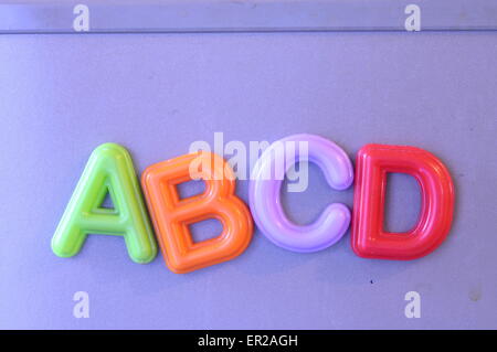 Colored magnetic letters on blue fridge writing abc Stock Photo