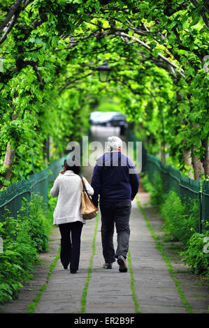 UK Weather: Bristol UK Monday 25 May 2015 A woman and man walk through an avenue of arched trees in Clifton at the end of the May Bank Holiday weekend in Bristol Stock Photo