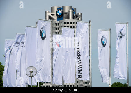 Munich, Germany. 11th May, 2015. Flags with the logo of German automobile manufacturing company BMW are pictured in front of the corporate headquarters, the BMW Tower, in Munich, Germany, 11 May 2015. BMW held its stockholders' meeting on 13 May 2015. Photo: Peter Kneffel/dpa/Alamy Live News Stock Photo