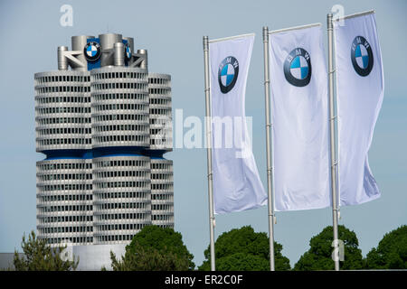 Munich, Germany. 11th May, 2015. Flags with the logo of German automobile manufacturing company BMW are pictured next to the corporate headquarters, the BMW Tower, in Munich, Germany, 11 May 2015. BMW held its stockholders' meeting on 13 May 2015. Photo: Peter Kneffel/dpa/Alamy Live News Stock Photo