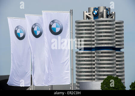 Munich, Germany. 11th May, 2015. Flags with the logo of German automobile manufacturing company BMW are pictured next to the corporate headquarters, the BMW Tower, in Munich, Germany, 11 May 2015. BMW held its stockholders' meeting on 13 May 2015. Photo: Peter Kneffel/dpa/Alamy Live News Stock Photo